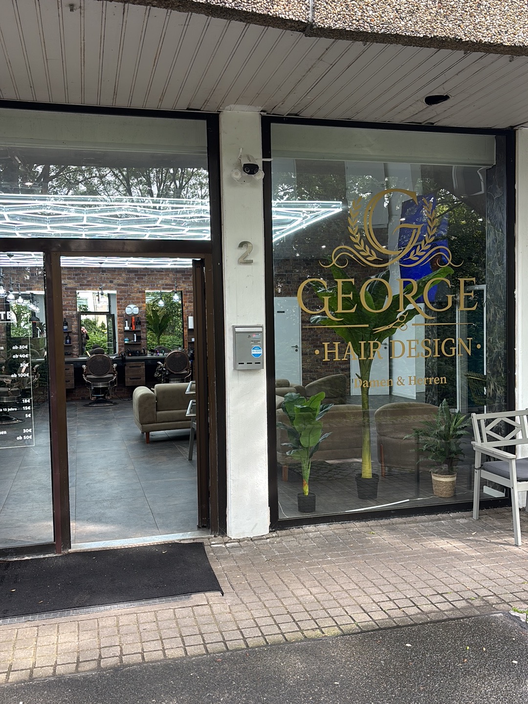 Salon-Schaufenster mit Gold-Logo und Einblick ins Interior